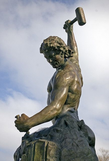 Bronze statue of a man raising a hammer